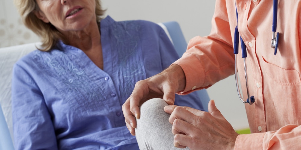 Hoe kan je fibromyalgie aantonen_ Afbeelding van een vrouw die een lichamelijk onderzoek krijgt van een arts om uit te beelden hoe je fibromyalgie kan aantonen